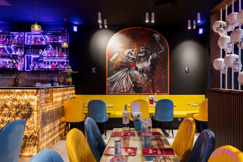 Inside a Tacos 'N' Tequilas Mexican restaurant — colourful dining room and bar